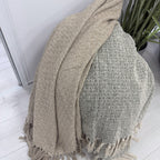 Take A Plaid TAP 2 Armygreen en Beige samen gedrapeerd over jute poef